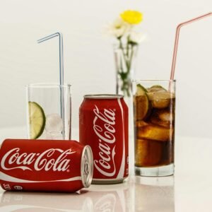 Coca-Cola cans with ice and lime on a table, fresh and invigorating.