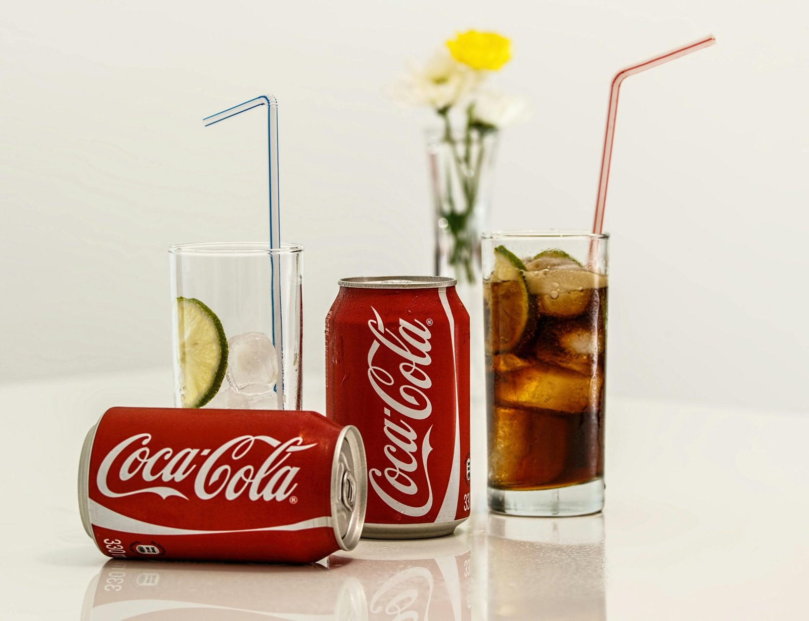 Coca-Cola cans with ice and lime on a table, fresh and invigorating.