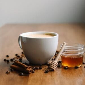 Warm chai with honey and cinnamon sticks on a wooden table, offering a cozy vibe.