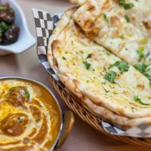 A delicious spread of Indian cuisine featuring curry, naan bread, and flavorful dishes.