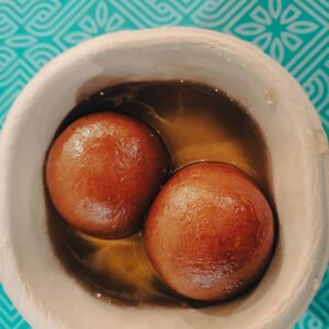 Savor the rich flavors of Indian Gulab Jamun served in an authentic clay pot. Perfect for festivals.