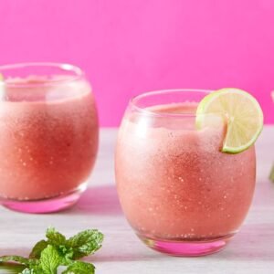 Two glasses of watermelon lime smoothies with mint, perfect for summer refreshments.