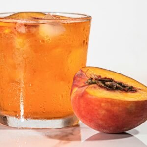 Close-up of a refreshing peach beverage with ice cubes, perfect for summer.